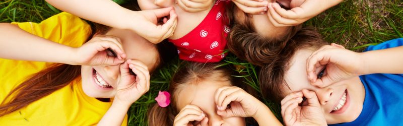 Group of cute children lying on grass